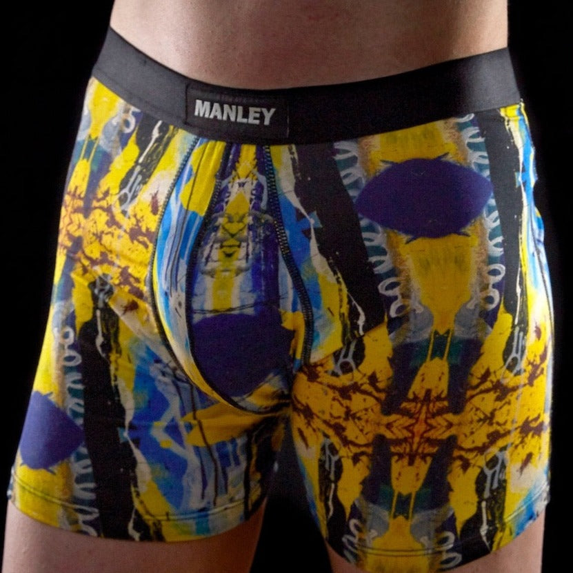 Manley Hello! Yellow boxer briefs, designed by artist Anthony Ricciardi, abstract design in blue, yellow, black, and white. Manley Barrier Technology that stops the pee spot. Feel manly in Manley. Stop the Pee Spot.  